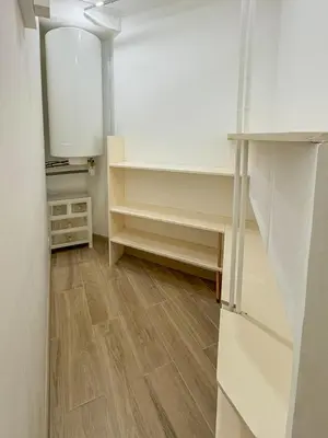 an empty kitchen with wooden floors and white cabinets at Gare Du Sud - Wifi, AC, balcon in Nice