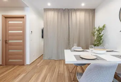 a white dining room with a table and chairs at LOFT à deux pas de la Mer avec terrasse n2 in Nice