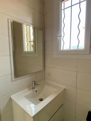 a white bathroom with a sink and a mirror at STUDIO VERT FSHH in Nice