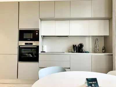 a kitchen with white cabinets and a table with chairs at Bright, newly renovated apartment in Nice