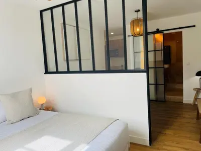a bedroom with a bed and a large mirror at Appartements Hotel le G in Nice