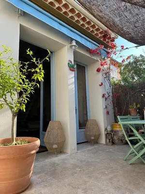 a patio with a table and chairs and a plant at Magnifique maison de pecheur face à la mer in Cagnes-sur-Mer