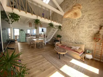 a living room with a couch and a stone wall at Magnifique maison de pecheur face à la mer in Cagnes-sur-Mer