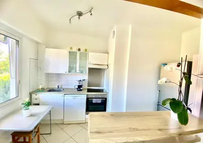 a kitchen with white appliances and a table at Grand 3 pièces avec parking à Nice Cimiez in Nice