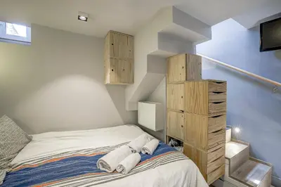 a small bedroom with a bed and wooden cabinets at Maison Bianchi - Jean Médecin in Nice