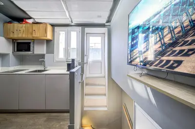 a kitchen with white cabinets and a tv on a wall at Maison Bianchi - Jean Médecin in Nice