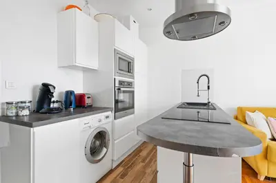 a white kitchen with a sink and a dishwasher at Terrasse des Oliviers in Nice