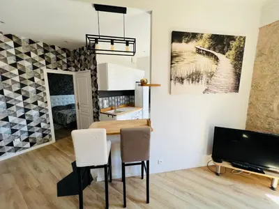 a dining room with a table and chairs and a tv at Joyau rare port de Nice in Nice