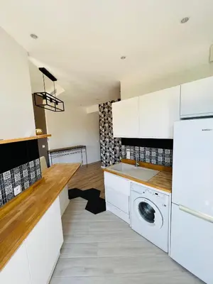 a kitchen with white cabinets and a washer and dryer at Joyau rare port de Nice in Nice