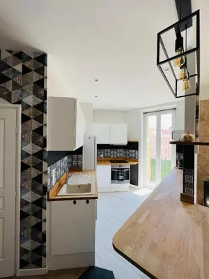 a kitchen with white cabinets and black and white tiles at Joyau rare port de Nice in Nice