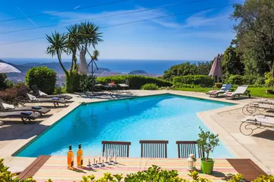 a swimming pool with chairs and umbrellas at LOU MAS SOUBRAN VI2083 by RIVIERA HOLIDAY HOMES in Nice