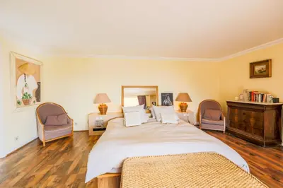 a bedroom with a large bed and two chairs at LOU MAS SOUBRAN VI2083 by RIVIERA HOLIDAY HOMES in Nice