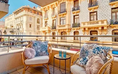 a balcony with chairs and a table and a building at Appartement Nice Palais de la Méditerranée in Nice