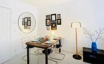 a dining room with a table and chairs and a mirror at Appartement Nice Palais de la Méditerranée in Nice