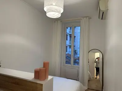 a person taking a picture of a bedroom with a mirror at Cosy Nice appartement in Nice