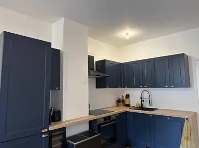 a kitchen with blue cabinets and a sink at Cosy Nice appartement in Nice