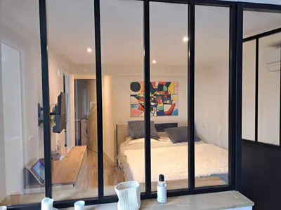a room with glass walls and a bedroom with a bed at Appartement 3 pièces à 5 minutes de la plage N7 in Saint-Laurent-du-Var