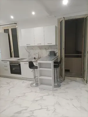 a kitchen with white cabinets and a marble floor at Appartement confortable a proximite de la mer. in Nice