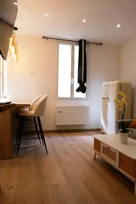 a kitchen with a table and a refrigerator in a room at Cocooning Atmosphère old Nice in Nice