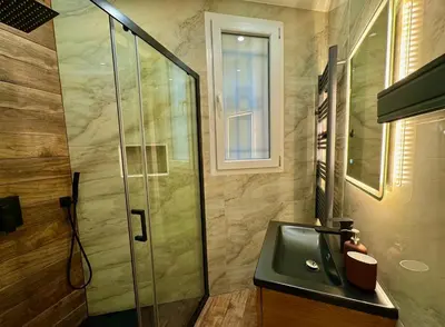 a bathroom with a glass shower and a sink at Central Riviera Charm in Nice
