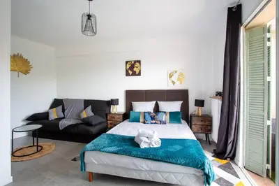 a bedroom with a bed and a couch at 4 pièces 8 personnes proche aéroport,tramway in Nice