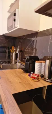 a kitchen with a wooden counter top with a telephone at 4 pièces 8 personnes proche aéroport,tramway in Nice