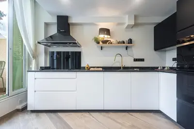 a kitchen with white cabinets and a sink at Villa fleurie in Cagnes-sur-Mer
