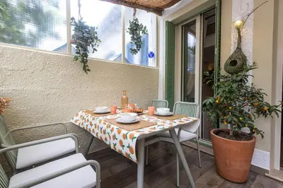 a table on a porch with a table and chairs at Villa fleurie in Cagnes-sur-Mer