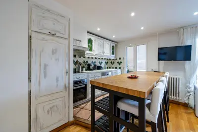 a kitchen with a wooden table and white cabinets at Appartement en plein coeur de Cagnes sur Mer in Cagnes-sur-Mer
