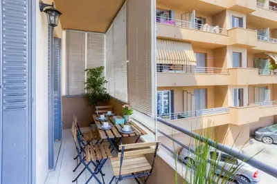 a balcony with a table and chairs and a building at Appartement en plein coeur de Cagnes sur Mer in Cagnes-sur-Mer
