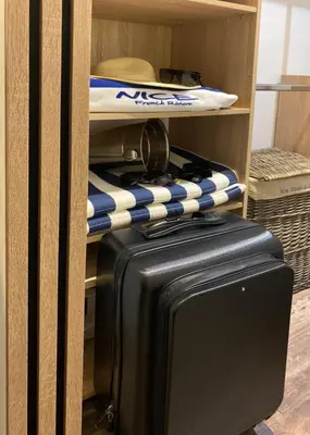 a suitcase and a surfboard on a shelf at Denis&kanya in Nice