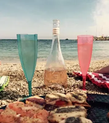 two wine glasses and a bottle on the beach at Denis&kanya in Nice