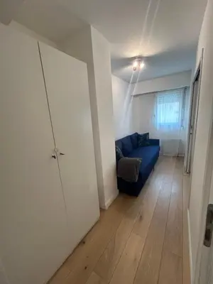 a living room with a blue couch and a door at Sunny Days in Nice