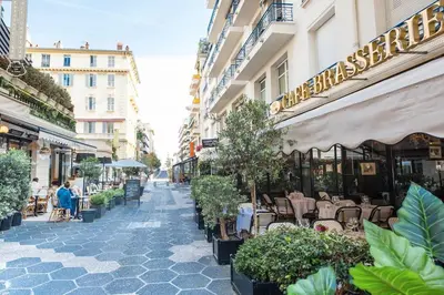 an empty street with tables and chairs and buildings at 50 meters from the beach ! Best location in Nice in Nice