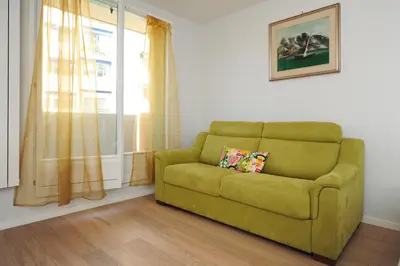 a green couch in a living room with a window at Blue Lagon Five Stars Holiday House in Nice