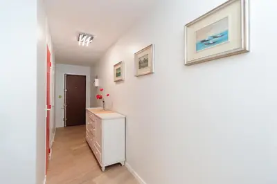 a room with white walls and a dresser and pictures on the wall at Blue Lagon Five Stars Holiday House in Nice