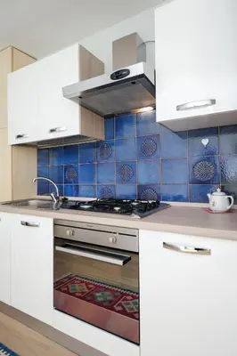 a kitchen with white appliances and blue tiles at Blue Lagon Five Stars Holiday House in Nice