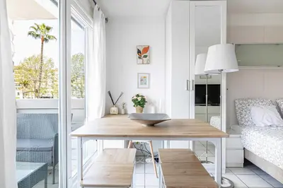 a living room with a table and a bed at Charming Studio with pool & balcony -Heart of Nice in Nice