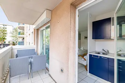 an apartment with a balcony with blue cabinets and a kitchen at Charming Studio with pool & balcony -Heart of Nice in Nice