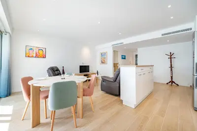 a kitchen and living room with a table and chairs at Magnifique T2, parking, face mer in Cagnes-sur-Mer