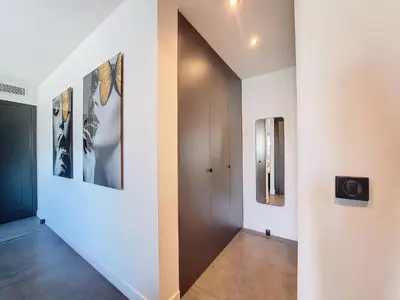 a hallway with a door and pictures on the wall at Nestor&Jeeves - LE ROYAL LUXEMBOURG - Sea view - Terrace in Nice