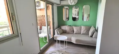 a living room with a couch and a table at 2 pièces au calme avec terrasse et climatisation in Nice