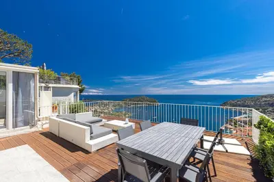 a patio with a table and chairs and the ocean at 73 CORNE D OR - Toit Terrasse - Vue Mer Panoramique - Jaccuzzi in Villefranche-sur-Mer