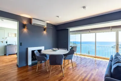 a living room with a table and chairs at 73 CORNE D OR - Toit Terrasse - Vue Mer Panoramique - Jaccuzzi in Villefranche-sur-Mer