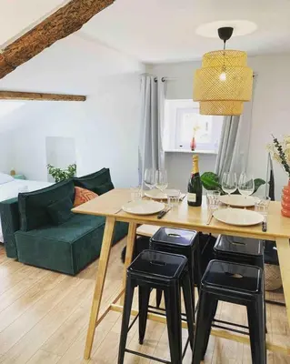 a dining room with a table and a green couch at Beautiful refurbished cozy apartment in Nice