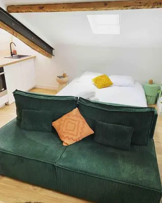 a green couch with a bed in a room at Beautiful refurbished cozy apartment in Nice