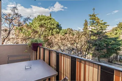 a table on a balcony with a view of trees at Beautiful 3 room apartment - Parking -Centre -Tram in Nice