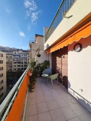 a balcony with a table and chairs on a building at Magnifique T3, spacieux, lumineux et traversant in Nice