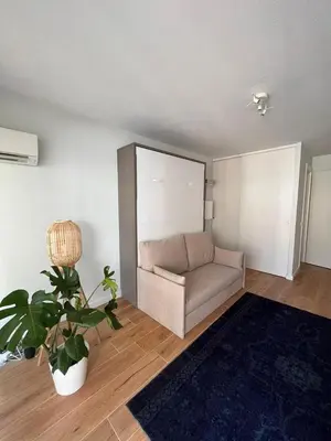 a living room with a couch and a potted plant at Beautiful studio - Terrace in Nice
