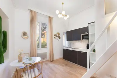 a kitchen with white walls and a white table and chairs at The Calypso - Quiet - New - Central in Nice